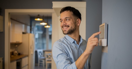 Young man adjusts the temperature at home