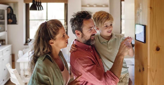 happy family looking at a smart thermostat