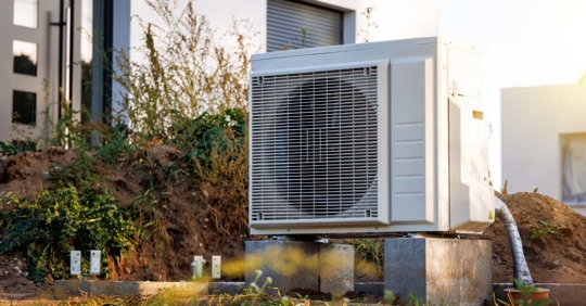 Heat pump outdoor unit in front of a house