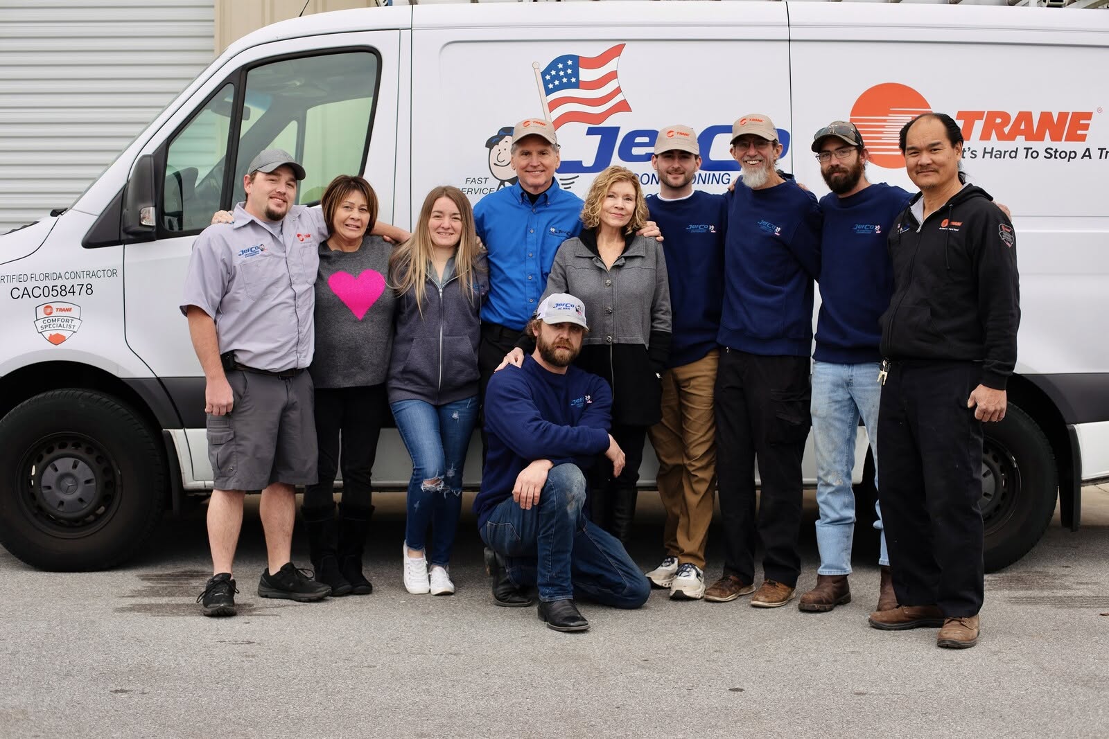 JefCo team posing in front of a white service van with logos.